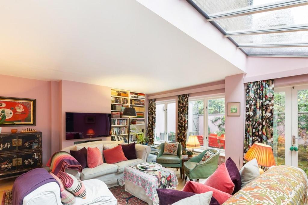 sala de estar con sofá y TV en Lovely 4-Bedroom House near Portobello, en Londres