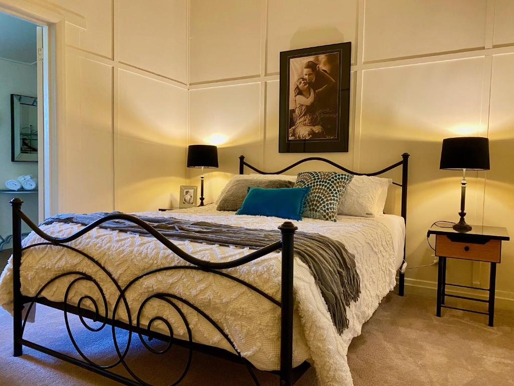 a bedroom with a bed and two lamps in it at Eugenie Cottage 1930s Art Deco in Bright