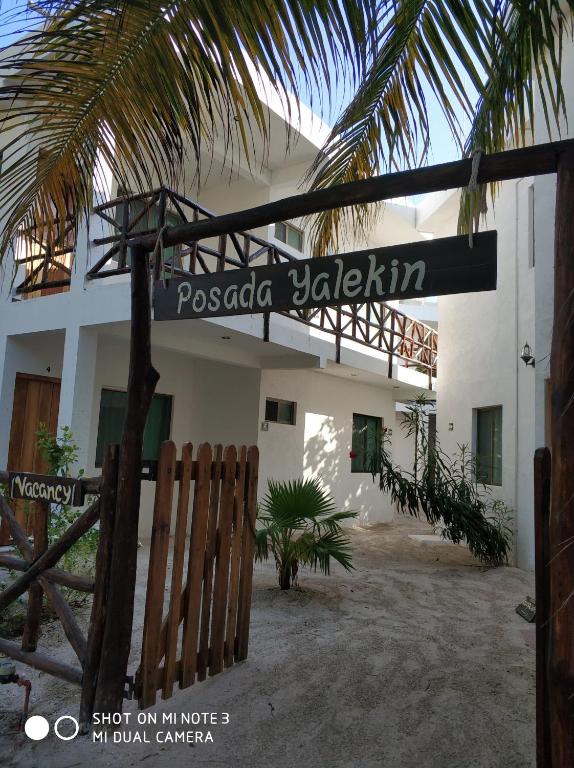 um sinal de rua em frente a um edifício branco em Posada Yalekin Holbox em Holbox