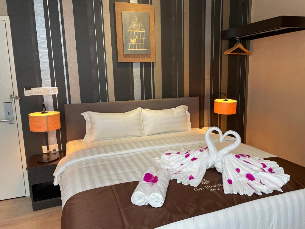 a hotel room with a bed with two pairs of slippers at Geo Boutique Hotel - Seri Kembangan in Seri Kembangan