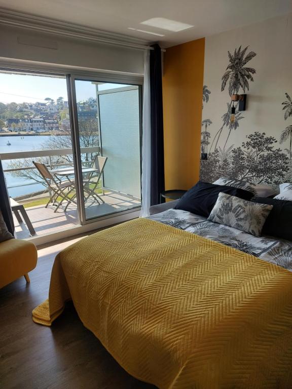 une chambre avec un lit et une vue sur l'eau dans l'établissement studio exposé plein sud vu sur le port de plaisance, à Perros-Guirec