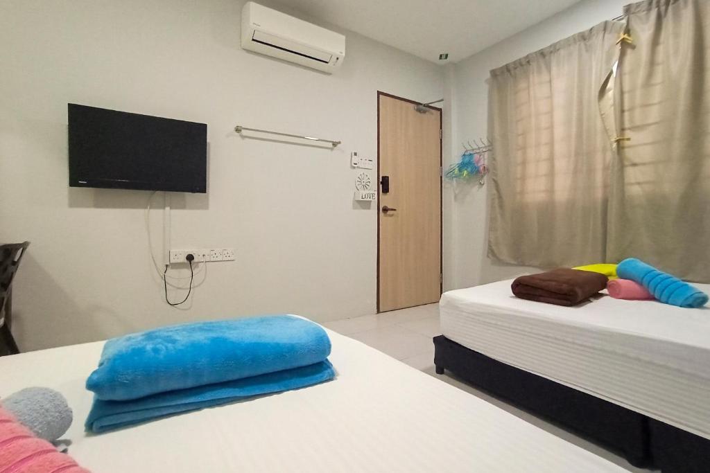Camera con 2 Letti e TV a parete di Hom2rex Kuching Homestay Taman Timberland a Kuching