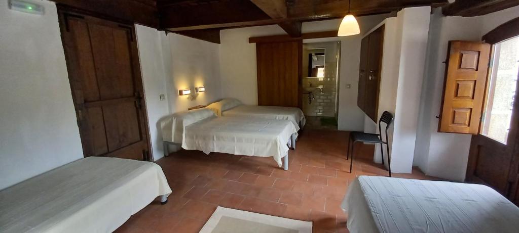 a bedroom with two beds in a room at Albergue Turístico "San Blas" de Oliva de Plasencia in Oliva de Plasencia