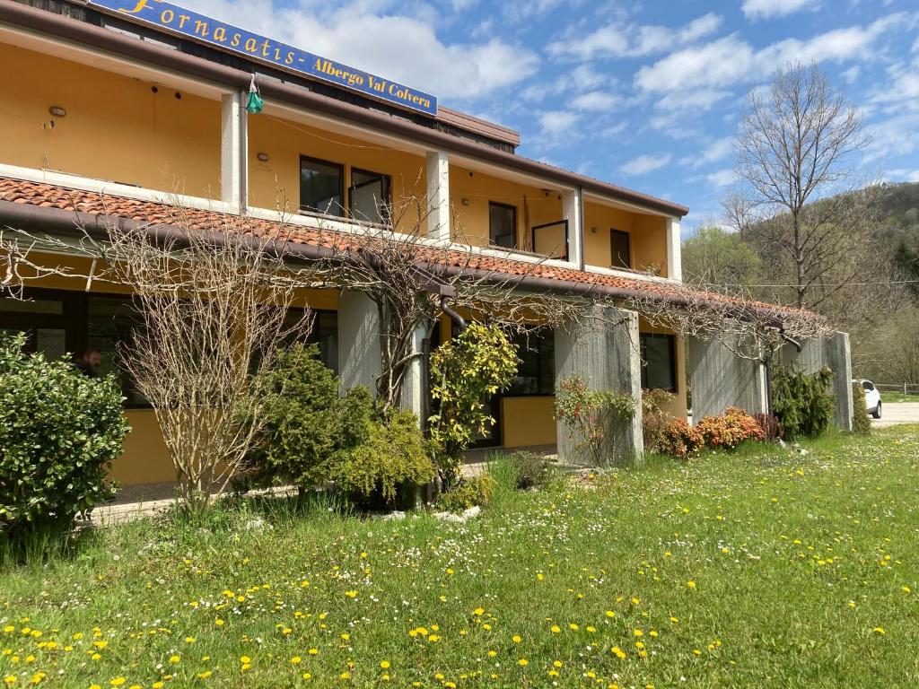 un edificio con un césped verde delante de él en Albergo Ristorante Lis Aganis, en Frisanco