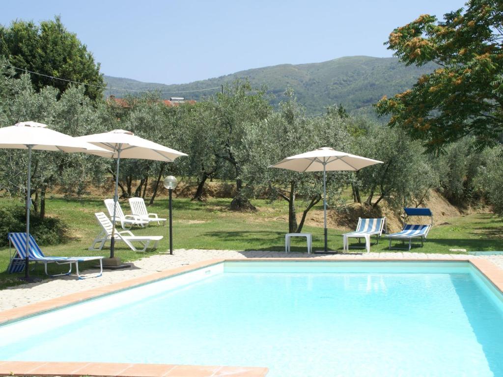 una piscina con sillas y sombrillas en Belvilla by OYO Podere Pulicciano, en Castelfranco di Sopra