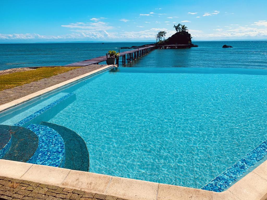 a large blue swimming pool next to the ocean at Libertalia Hotel in Sainte Marie