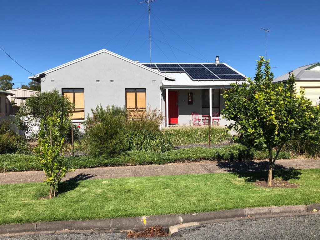 ein weißes Haus mit Sonnenkollektoren auf dem Dach in der Unterkunft The Red Door in Mount Gambier