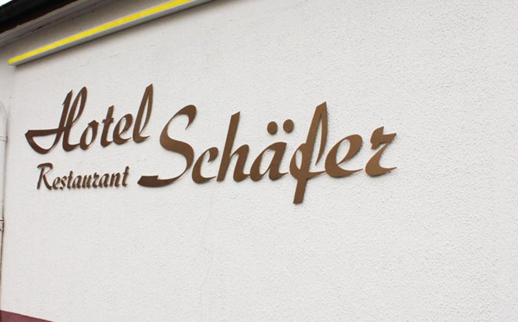 een bord voor een hotel shilleler aan de zijkant van een gebouw bij Hotel Schäfer in Siegen