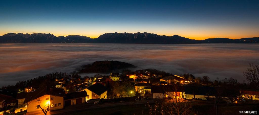 uma cidade no meio de um campo de nevoeiro ao pôr do sol em Hotel Viktor em Viktorsberg