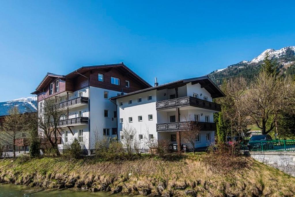 a building on a hill next to a river at Chalet Wallner by AlpentTravel in Bad Hofgastein