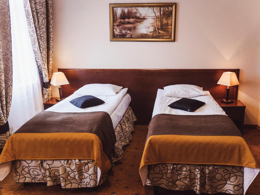 dwa łóżka w pokoju hotelowym z dwoma lampami w obiekcie Hotel Osjann w Białej Podlaskiej