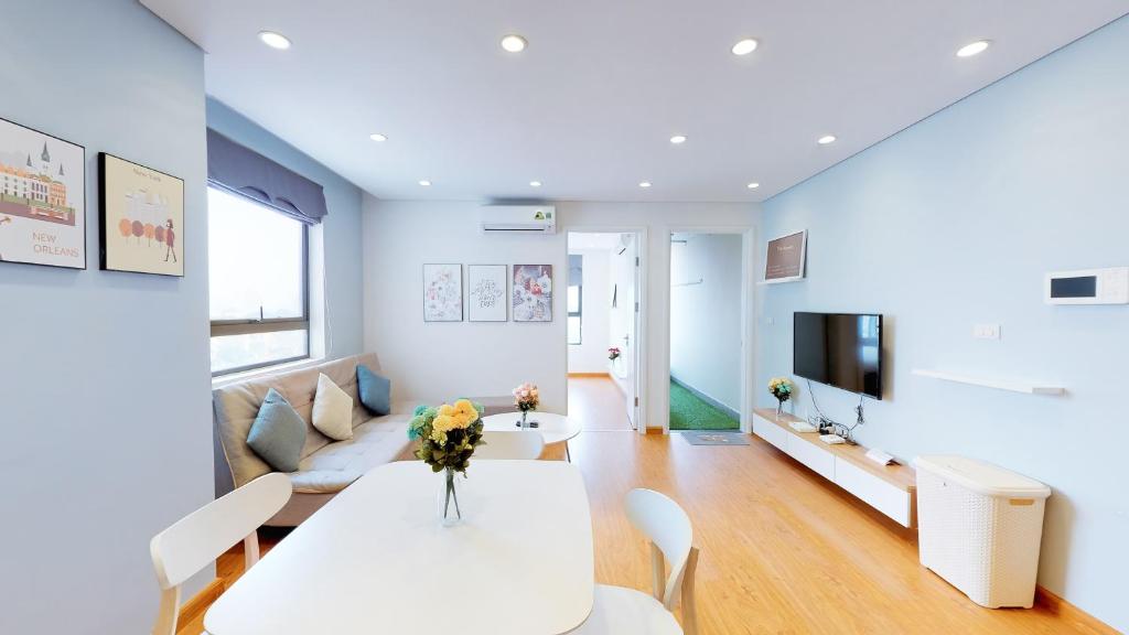 a living room with a white table and a couch at HongKong Tower managed by Lily Home in Hanoi