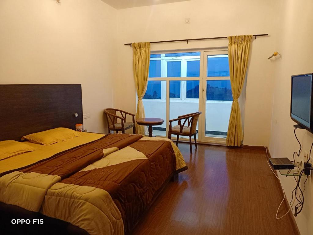 a bedroom with a bed and a large window at Apple Breeze Resort in Kotagiri