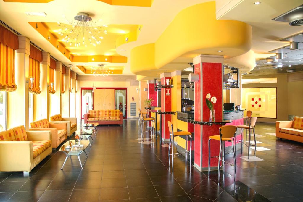a lobby with couches and chairs and a bar at Hotel Mediterraneo in Livorno