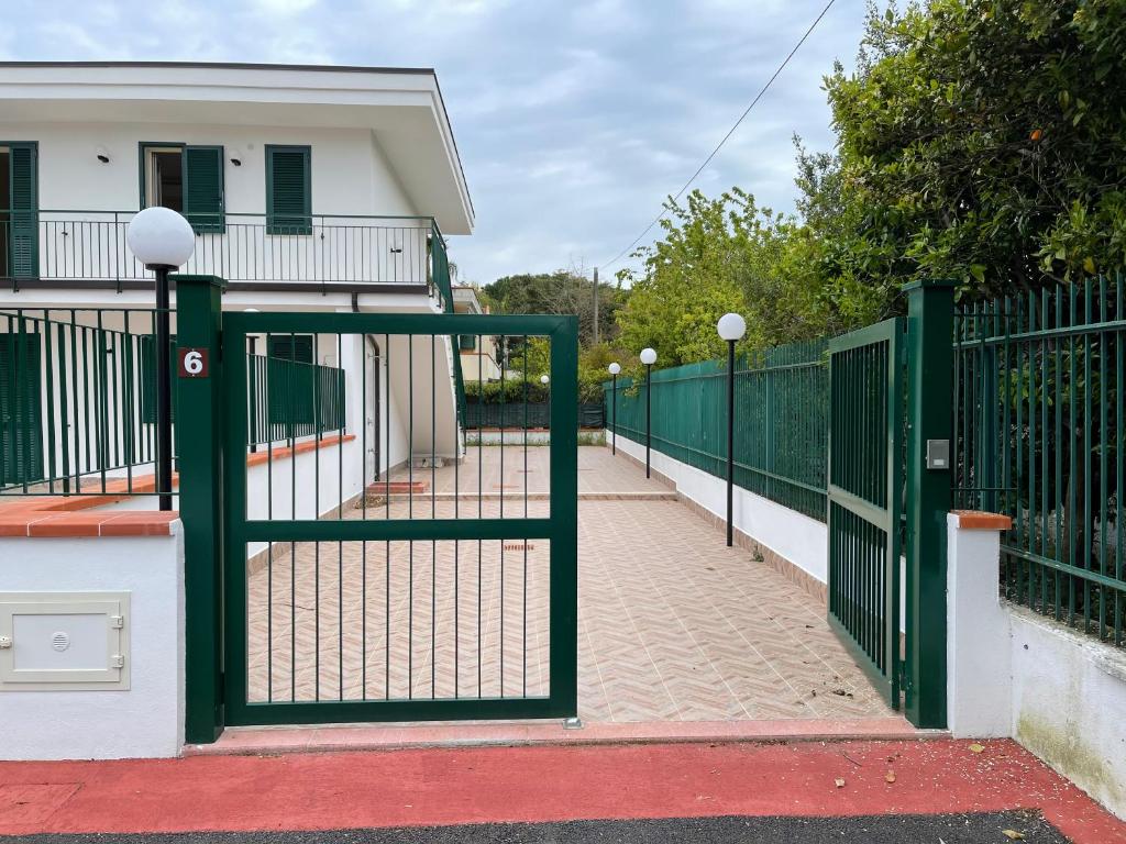 a green gate in front of a house at Costa Paestum Apartment in Paestum