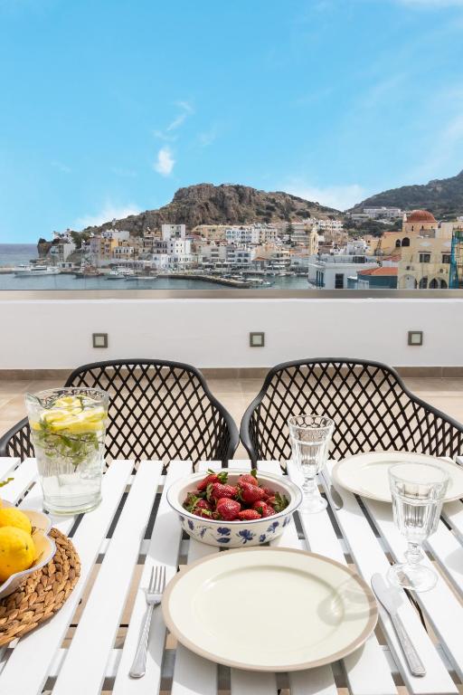 a white table with a bowl of fruit on it at Olia Boutique Apartments in Karpathos