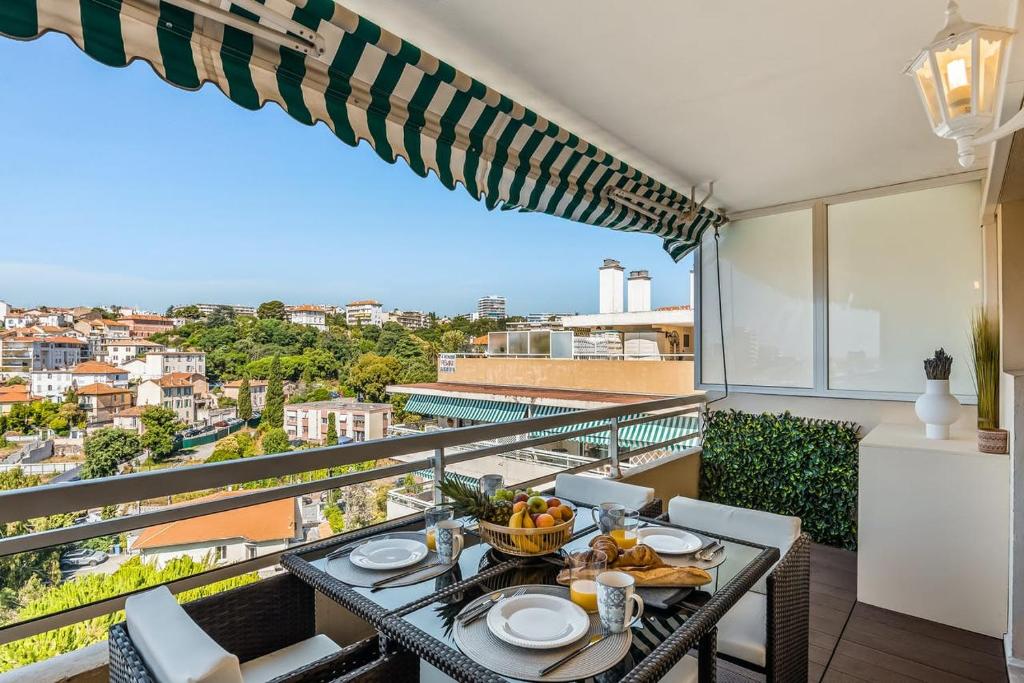 - une table avec de la nourriture sur un balcon avec vue dans l'établissement Petit Juas Apartment, à Cannes
