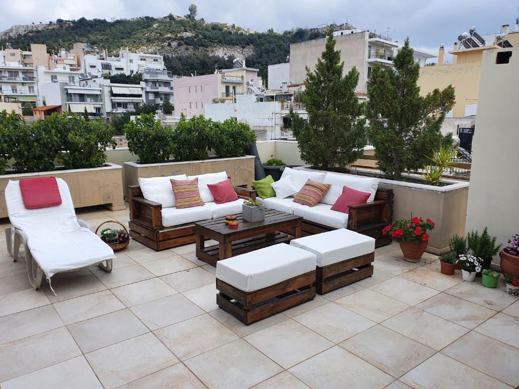 a patio with couches and chairs on a rooftop at Amazing Views 1 in Athens