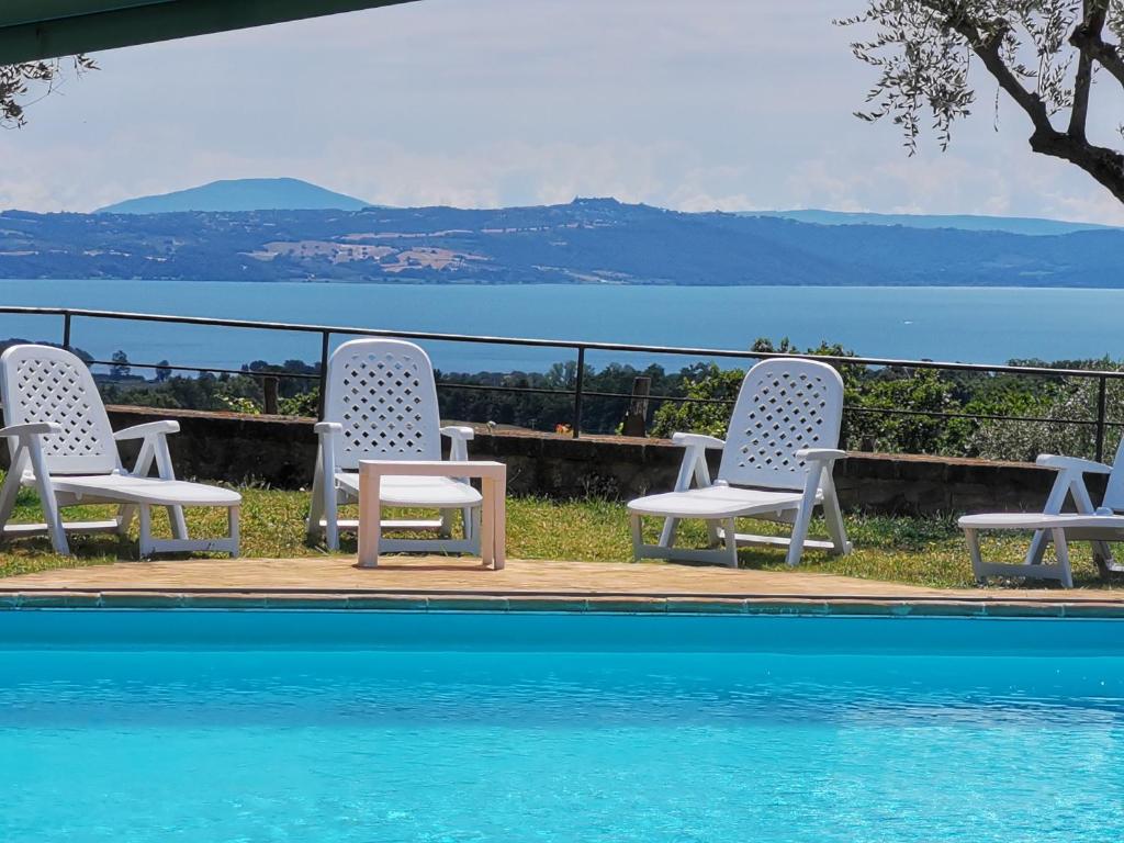 un grupo de sillas sentadas junto a una piscina en Villa Ulivo, en Grotte di Castro