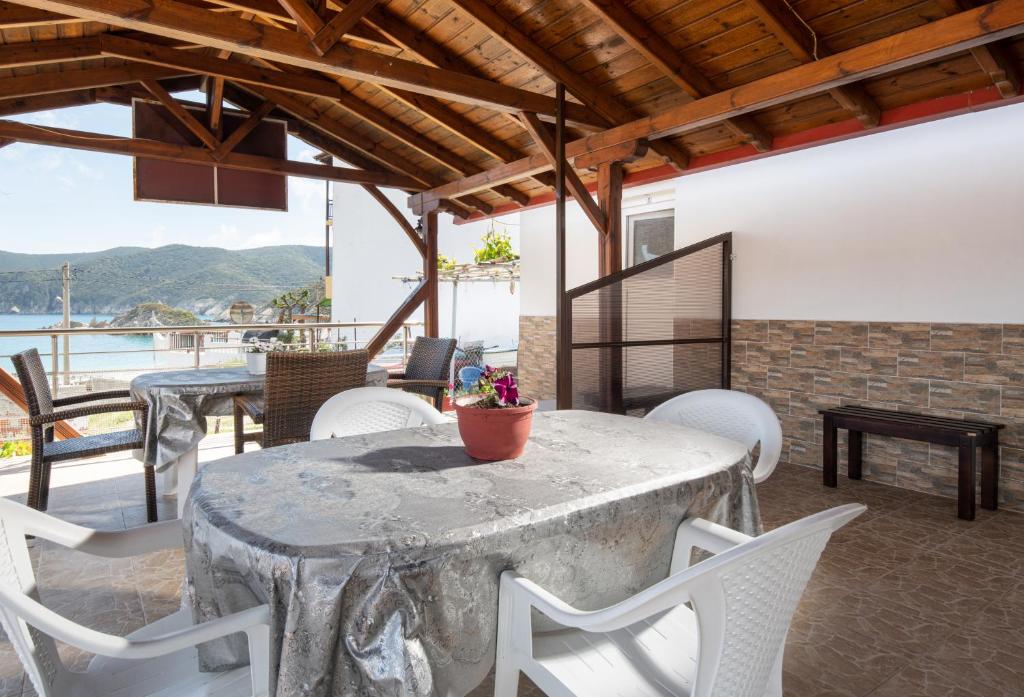 a table and chairs on a patio with a view of the water at Lofos Kalamitsi in Kalamitsi