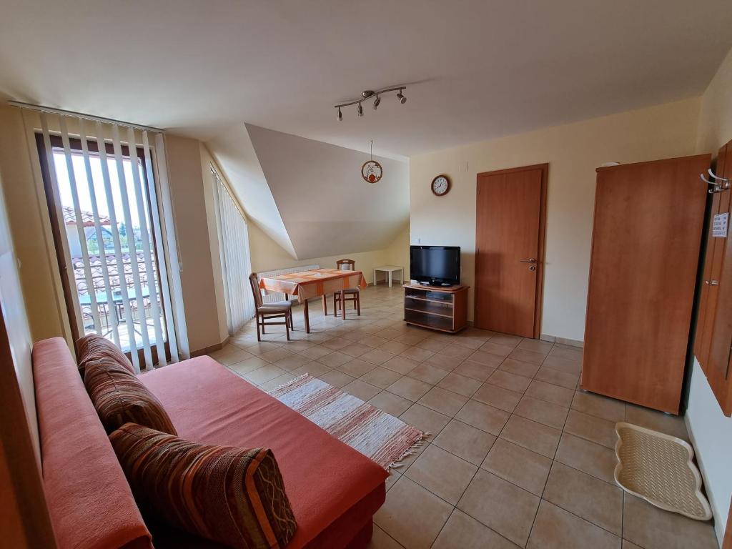 ein Wohnzimmer mit einem Sofa und einem Tisch in der Unterkunft Mónika apartman in Bük