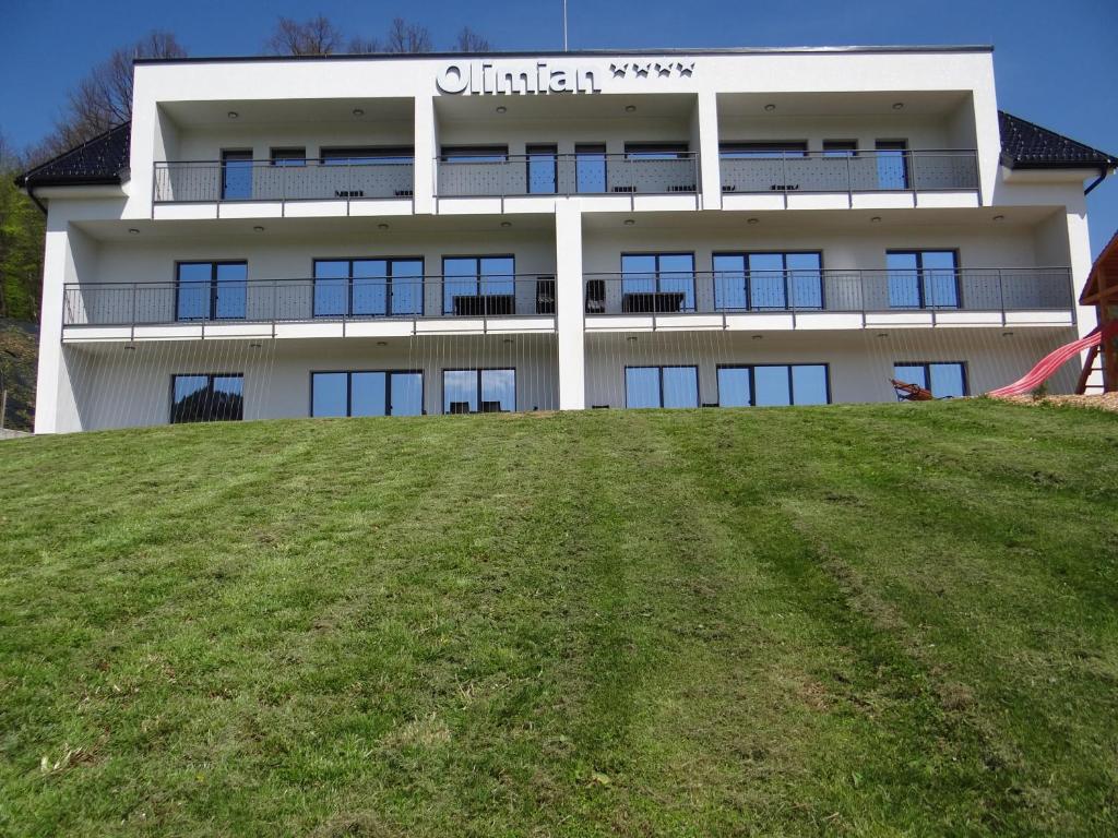 un bâtiment au sommet d'une colline avec un champ vert dans l'établissement Relax Center Olimian, à Podčetrtek