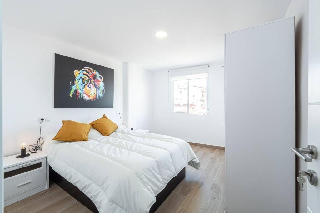 a white bedroom with a large bed and a window at The rest between Picasso & Pompidou in Málaga