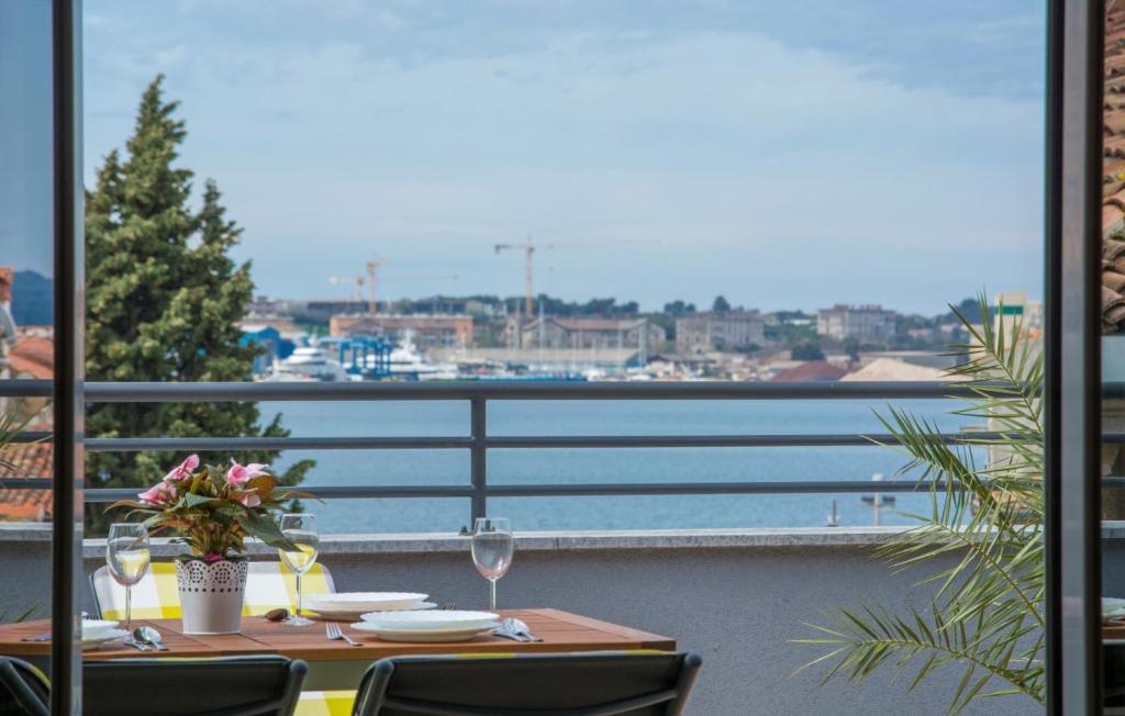 una mesa con copas de vino y vistas al agua en City Centre Sea View Apartment, en Pula