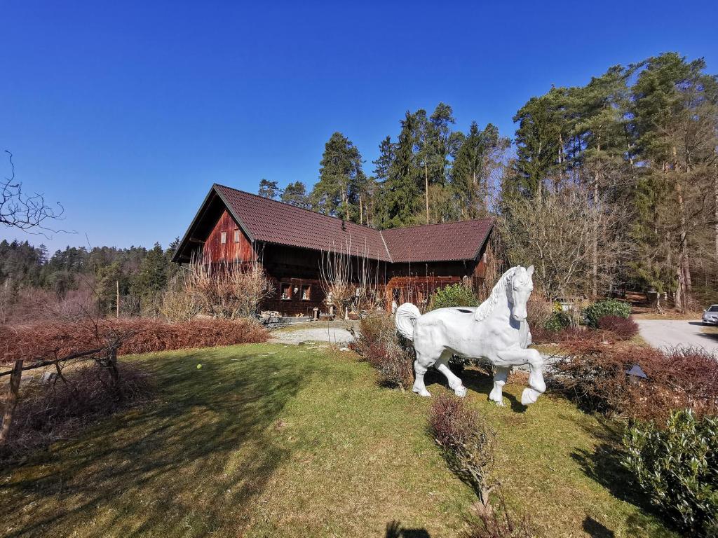 a statue of a white horse in front of a house at Ranch Kaja & Grom in Vojnik