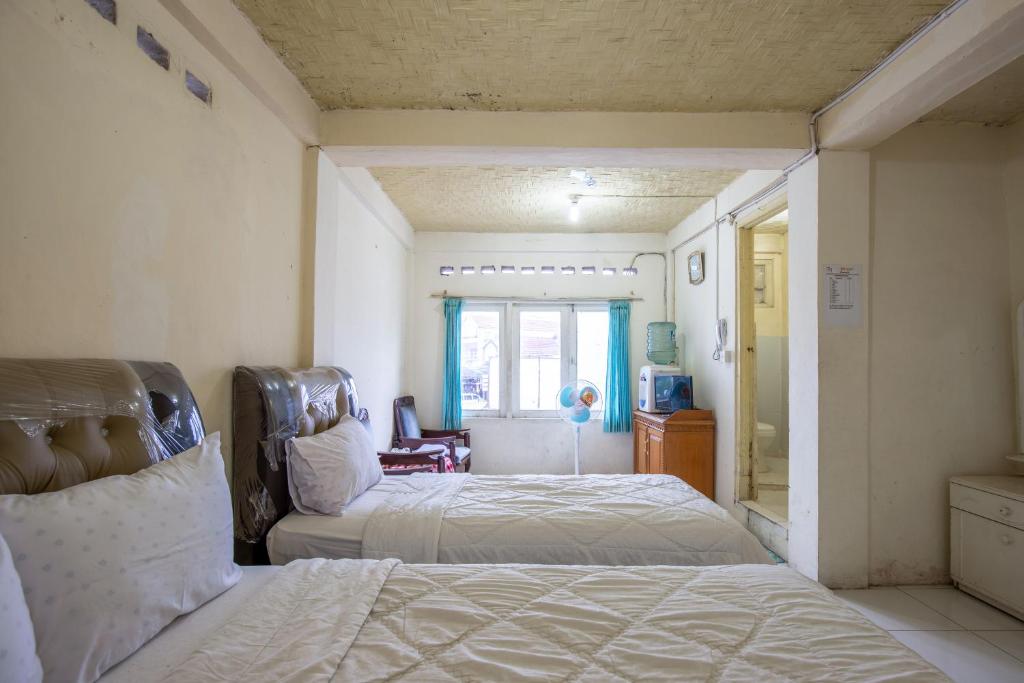 Postel nebo postele na pokoji v ubytování Hotel Jogja Bukittinggi