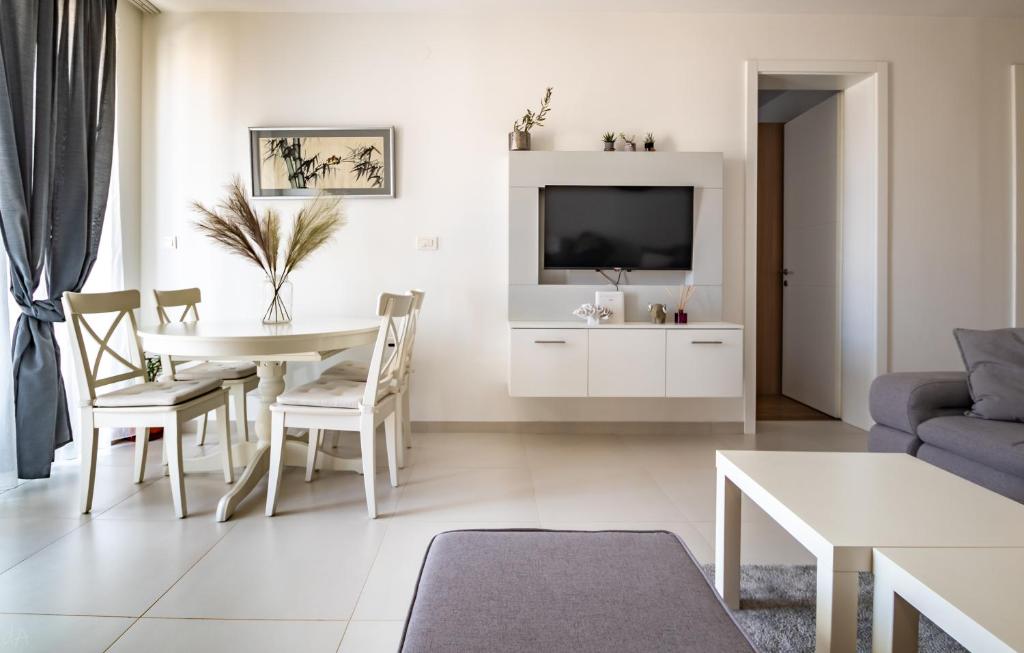 uma sala de estar com uma mesa e uma televisão em La Perla Jacuzzi em Murter