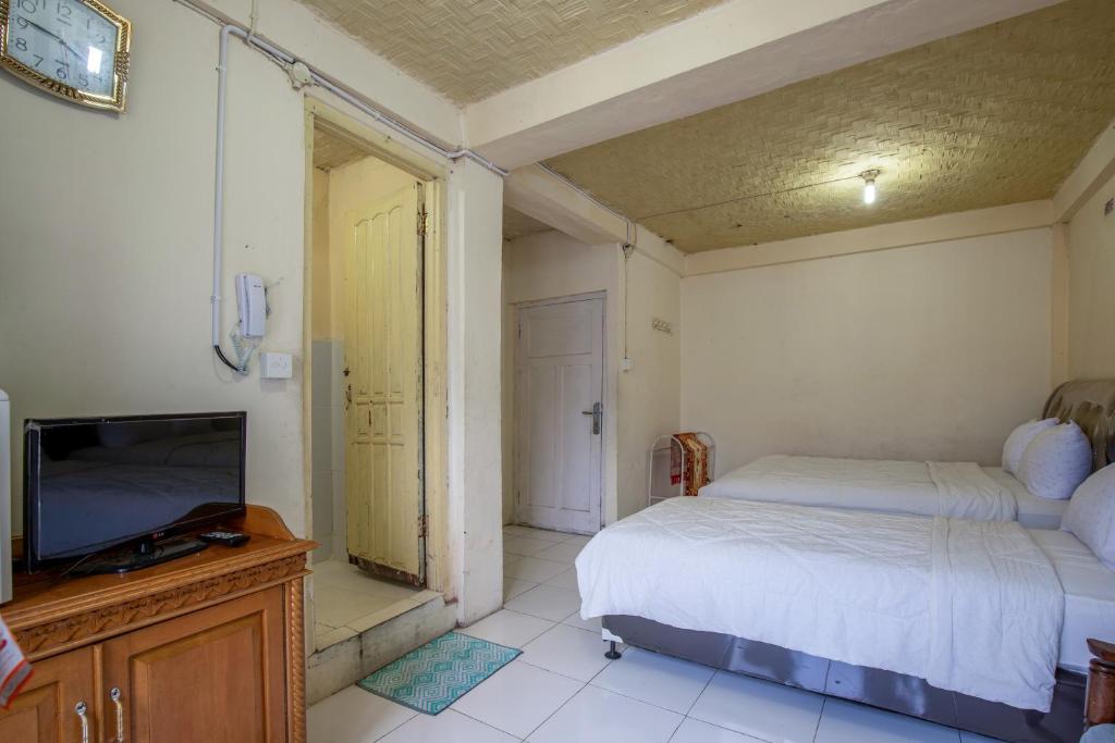 Postel nebo postele na pokoji v ubytování Hotel Jogja Bukittinggi