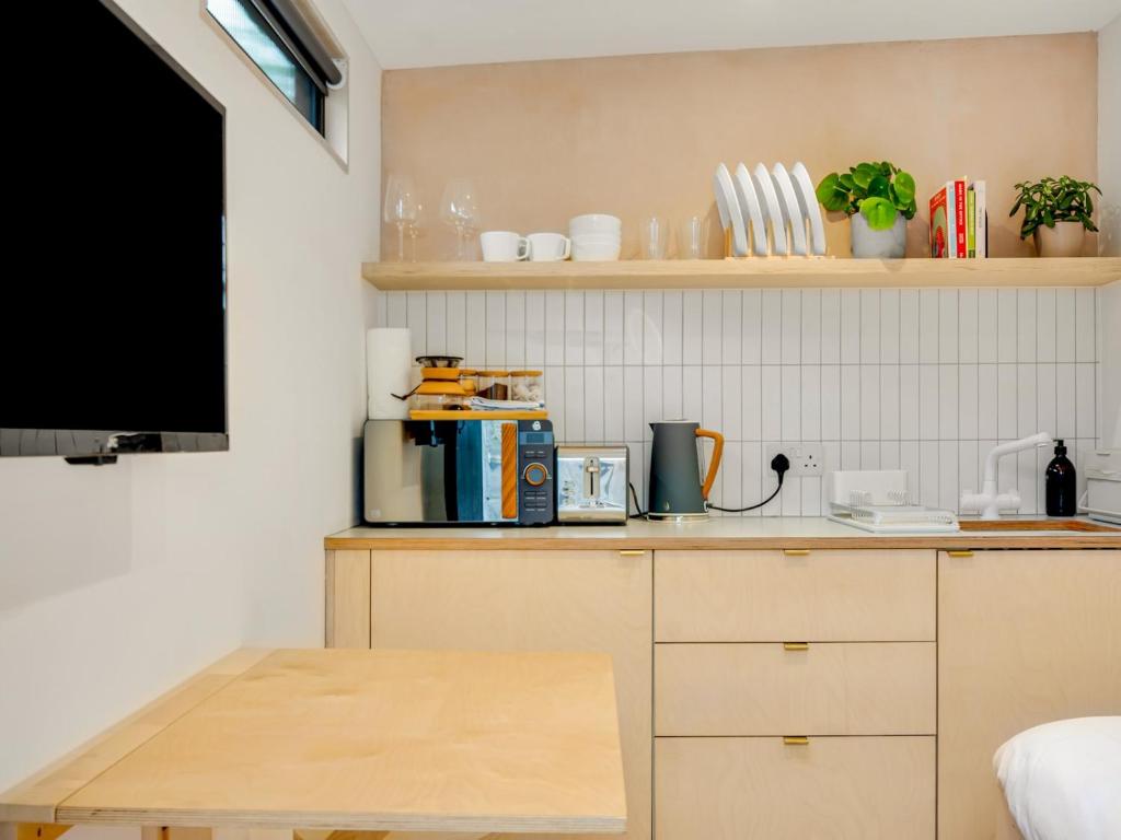 a small kitchen with a table and a tv at Pass the Keys Whitstable Tiny house - a secret getaway! in Whitstable