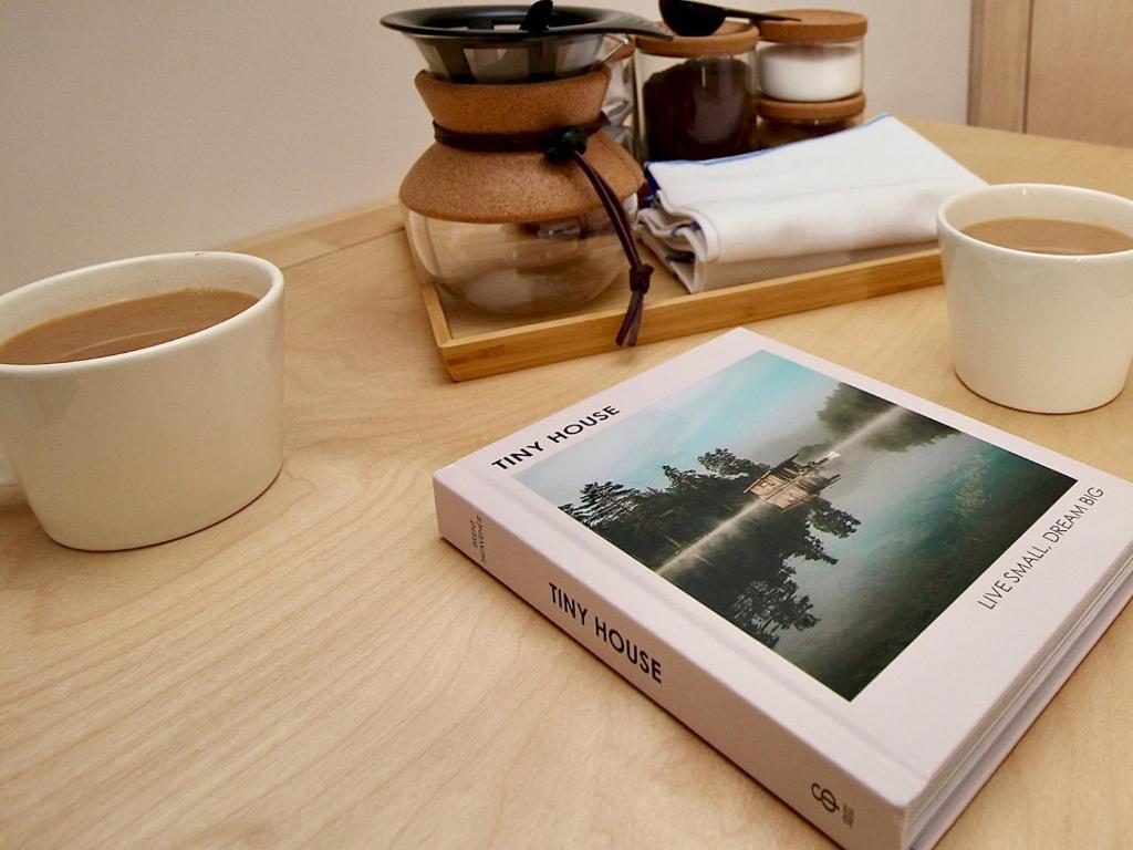 a book sitting on a table next to a cup of coffee at Pass the Keys Whitstable Tiny house - a secret getaway! in Whitstable