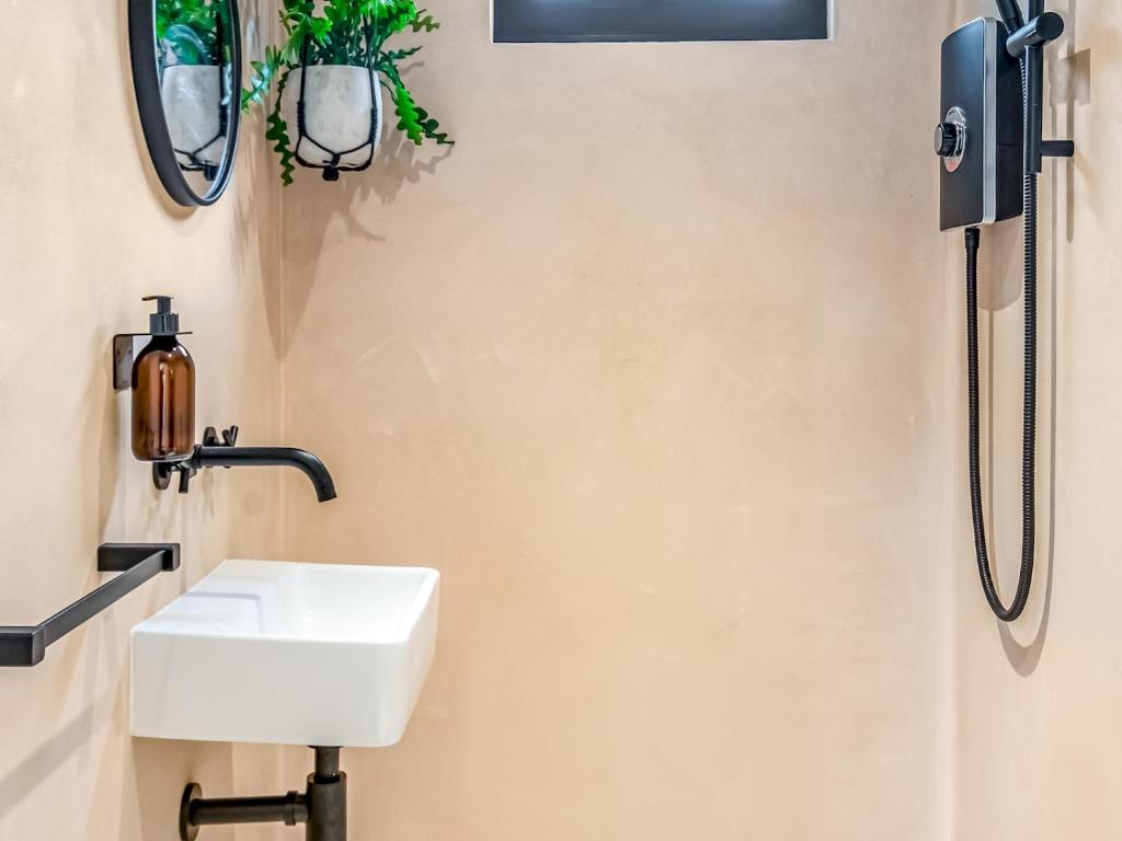 a bathroom with a sink and a shower at Pass the Keys Whitstable Tiny house - a secret getaway! in Whitstable