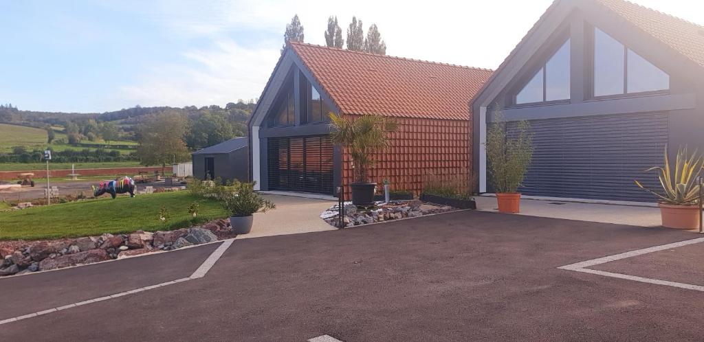 une grande maison avec une allée et un garage dans l'établissement la douce Cahute, à Fresnicourt-le-Dolmen