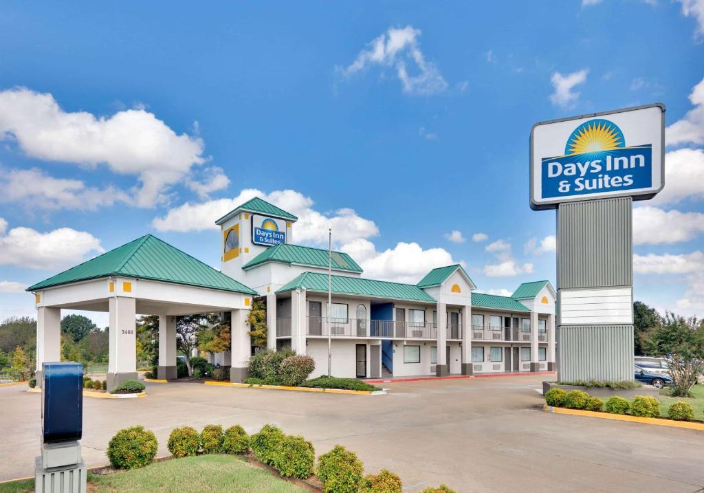 a days inn and suites sign in front of a building at Days Inn & Suites by Wyndham Bentonville in Bentonville