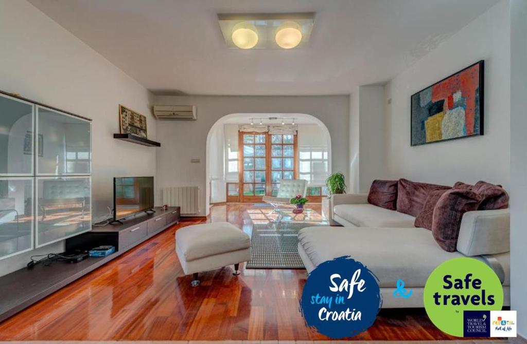 ein Wohnzimmer mit einem Sofa und einem TV in der Unterkunft LCT Dream Luxury Villa in Split