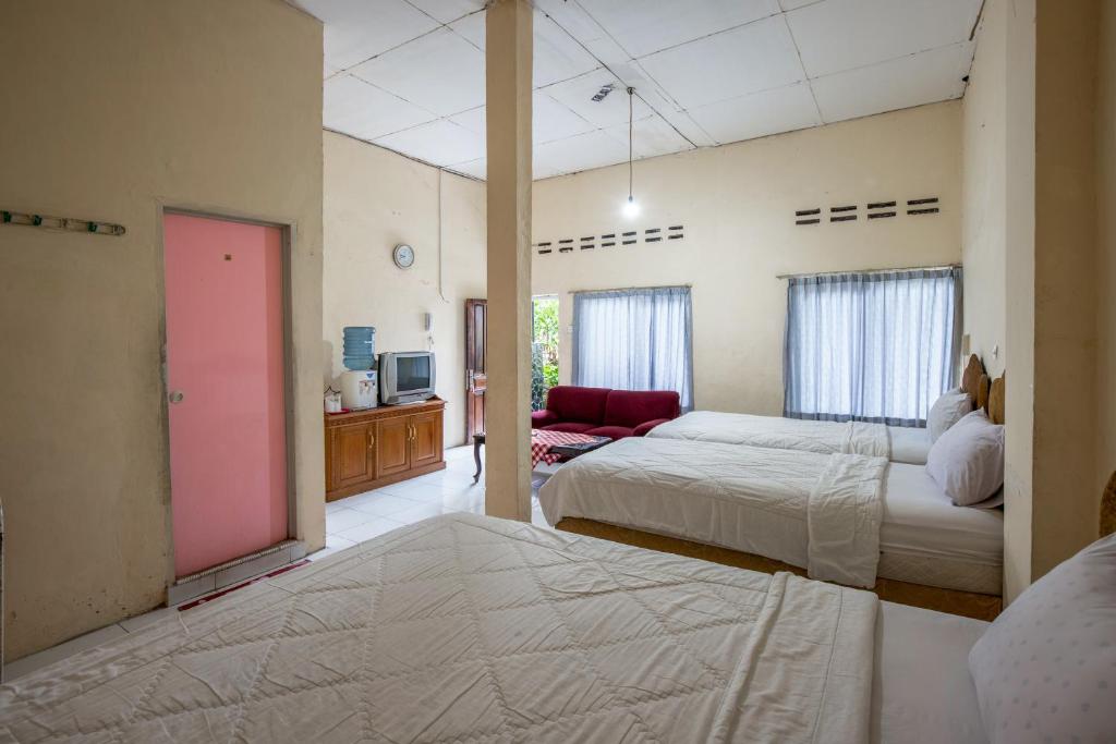 Postel nebo postele na pokoji v ubytování Hotel Jogja Bukittinggi