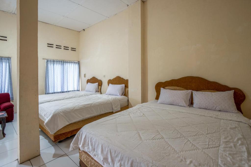 Postel nebo postele na pokoji v ubytování Hotel Jogja Bukittinggi