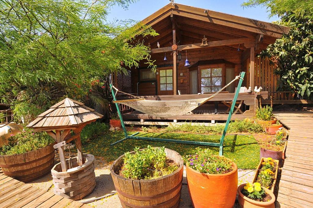 een huis met een hangmat en planten ervoor bij הפינה היפה של צביה in Had Nes