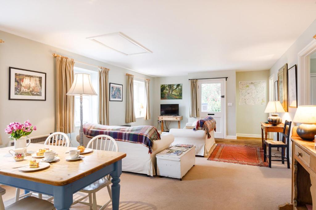 a living room with a couch and a table at Stable Cottage - Milton Lilbourne in Pewsey