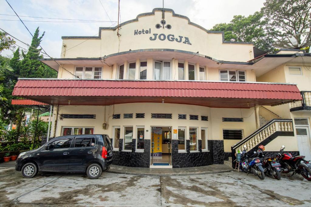 a building with motorcycles parked in front of it at Hotel Jogja Bukittinggi in Bukittinggi