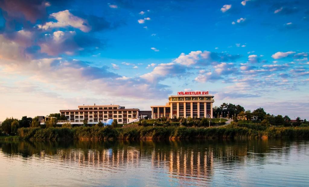 a building on a hill next to a body of water at Ankara Vilayetler Evi in Golbası