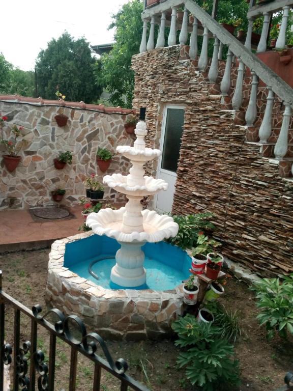 a fountain in a yard next to a staircase at Casa de vacanta in Eforie Nord