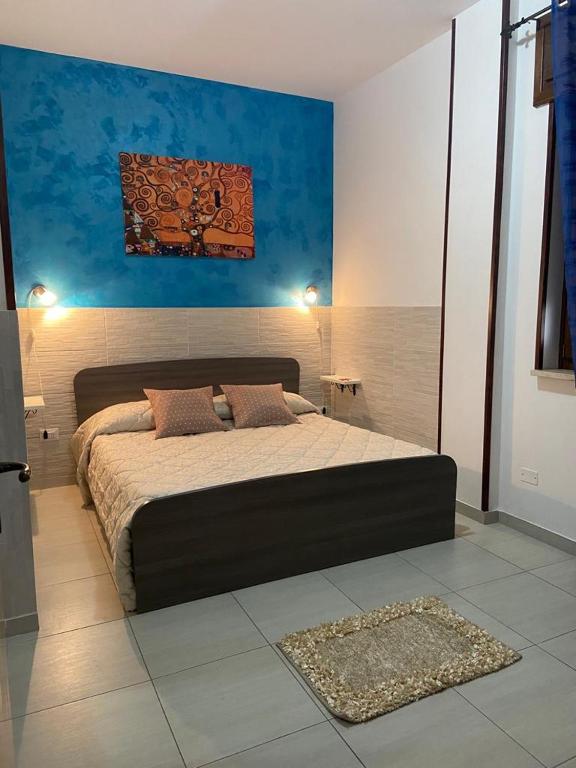 ein Schlafzimmer mit einem großen Bett in einem Zimmer in der Unterkunft Bilocale Blu - A casa di Ludovica e Martina in Gallipoli