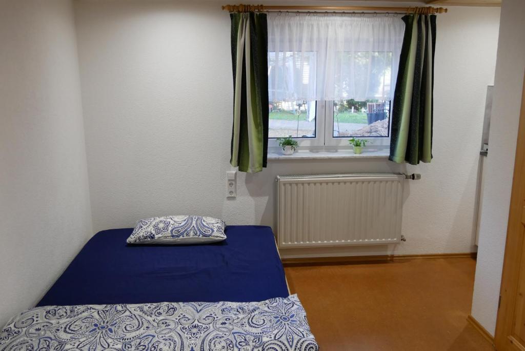 a small bedroom with a bed and a window at FerienZimmer in Niederstetten
