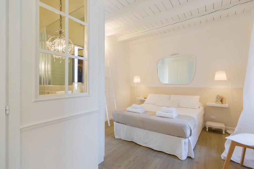 - une chambre blanche avec un lit et un miroir dans l'établissement Uno splendido punto a Verona!!, à Vérone