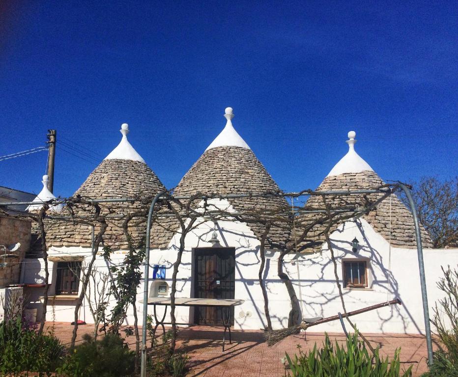 a white building with a roof with a sky at Trullo Cicerone in Martina Franca