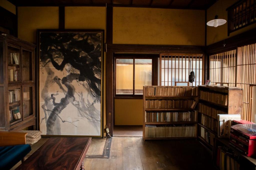 旧鈴木邸 女性専用 في ماتسوياما: غرفة مع باب مع لوحة على الحائط